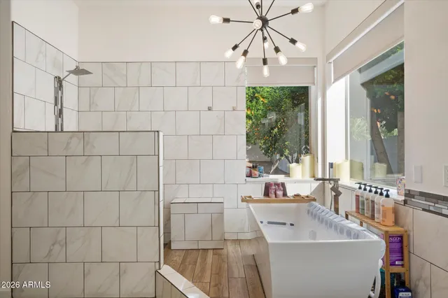 a bathroom with a sink a large mirror and a bathtub