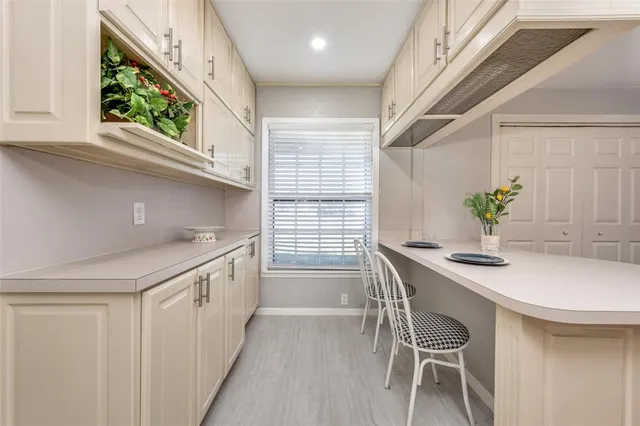 a kitchen with kitchen island a table chairs sink and wooden floor