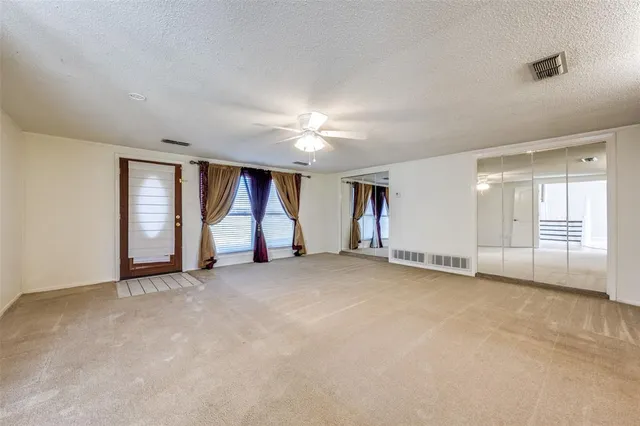an empty room with a fireplace and large window