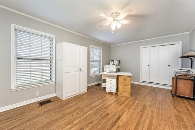 a view of a livingroom with furniture a ceiling fan and wooden floor