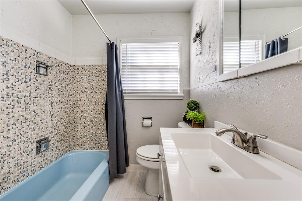 909 Coffield Street Bowie, TX 76230 - Photo 21 of 25 a bathroom with a sink a toilet and a bathtub