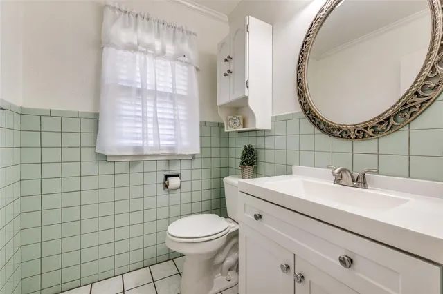 a bathroom with a sink a toilet and a mirror