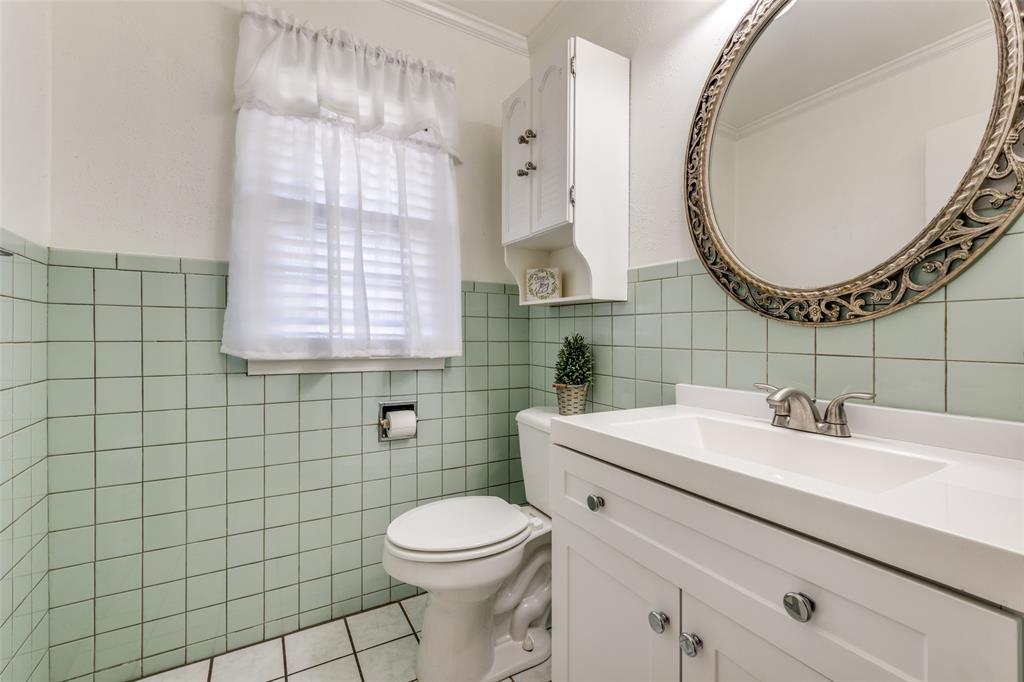 909 Coffield Street Bowie, TX 76230 - Photo 23 of 25 a bathroom with a sink a toilet and a mirror