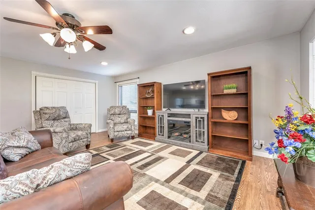 a bedroom with a bed chandelier dresser and a window