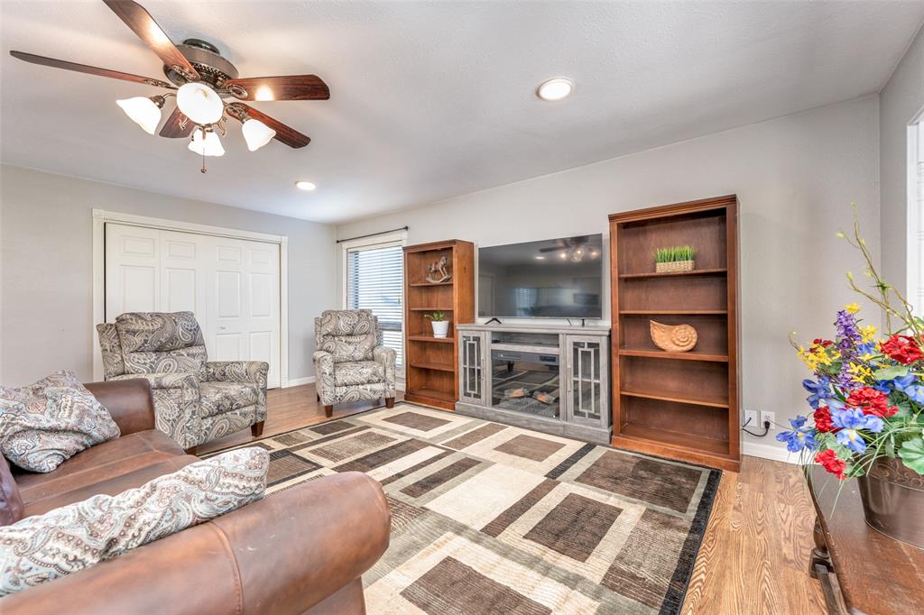909 Coffield Street Bowie, TX 76230 - Photo 6 of 25 a bedroom with a bed chandelier dresser and a window