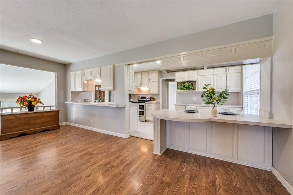 909 Coffield Street Bowie, TX 76230 - Photo 8 of 25 a living room with stainless steel appliances kitchen island granite countertop a sink dishwasher and a stove with wooden floor