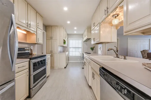 a kitchen with a sink stove top oven and cabinets
