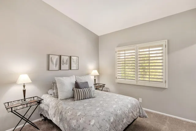 a bedroom with a bed and a lamp next to a window