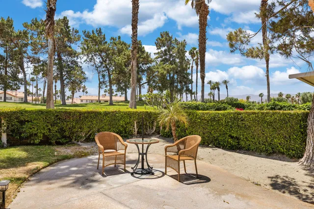 a view of a chairs and table in backyard of the house