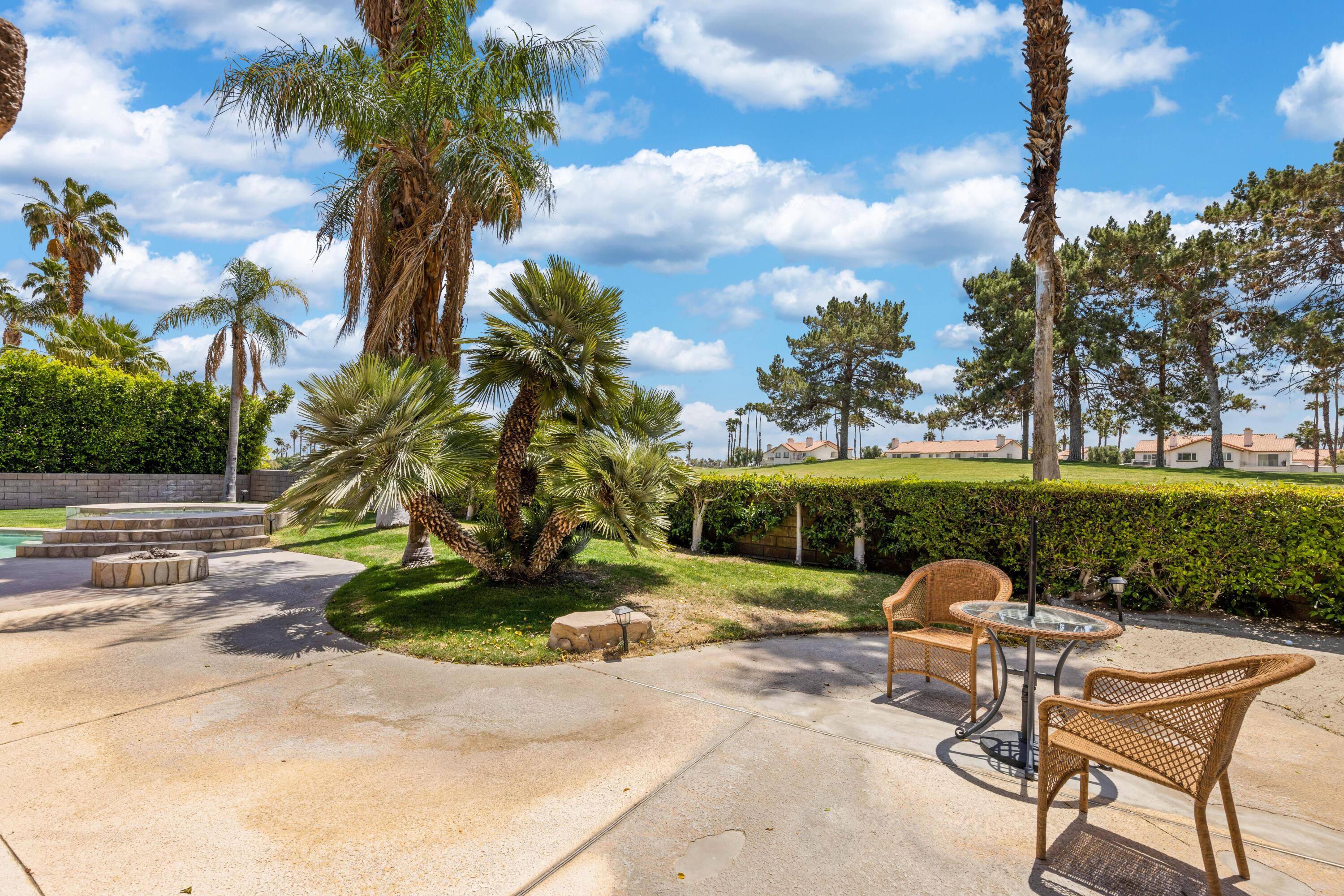 351 Augusta Drive Palm Desert, CA 92211 - Photo 22 of 26 a view of a patio with a table chairs couches and a fire pit