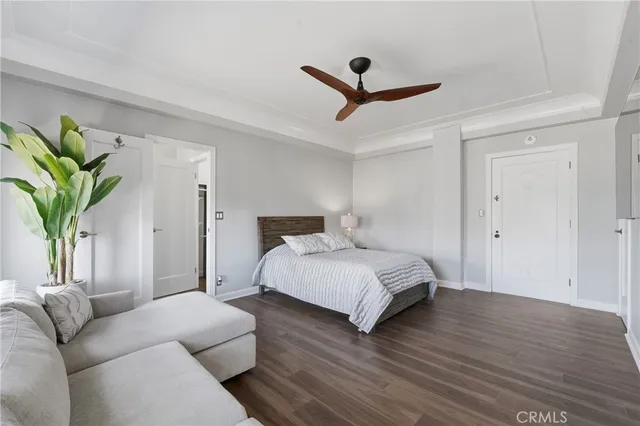 a bedroom with a bed a couch and a potted plant