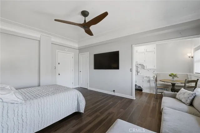 a spacious bedroom with a bed and a flat screen tv