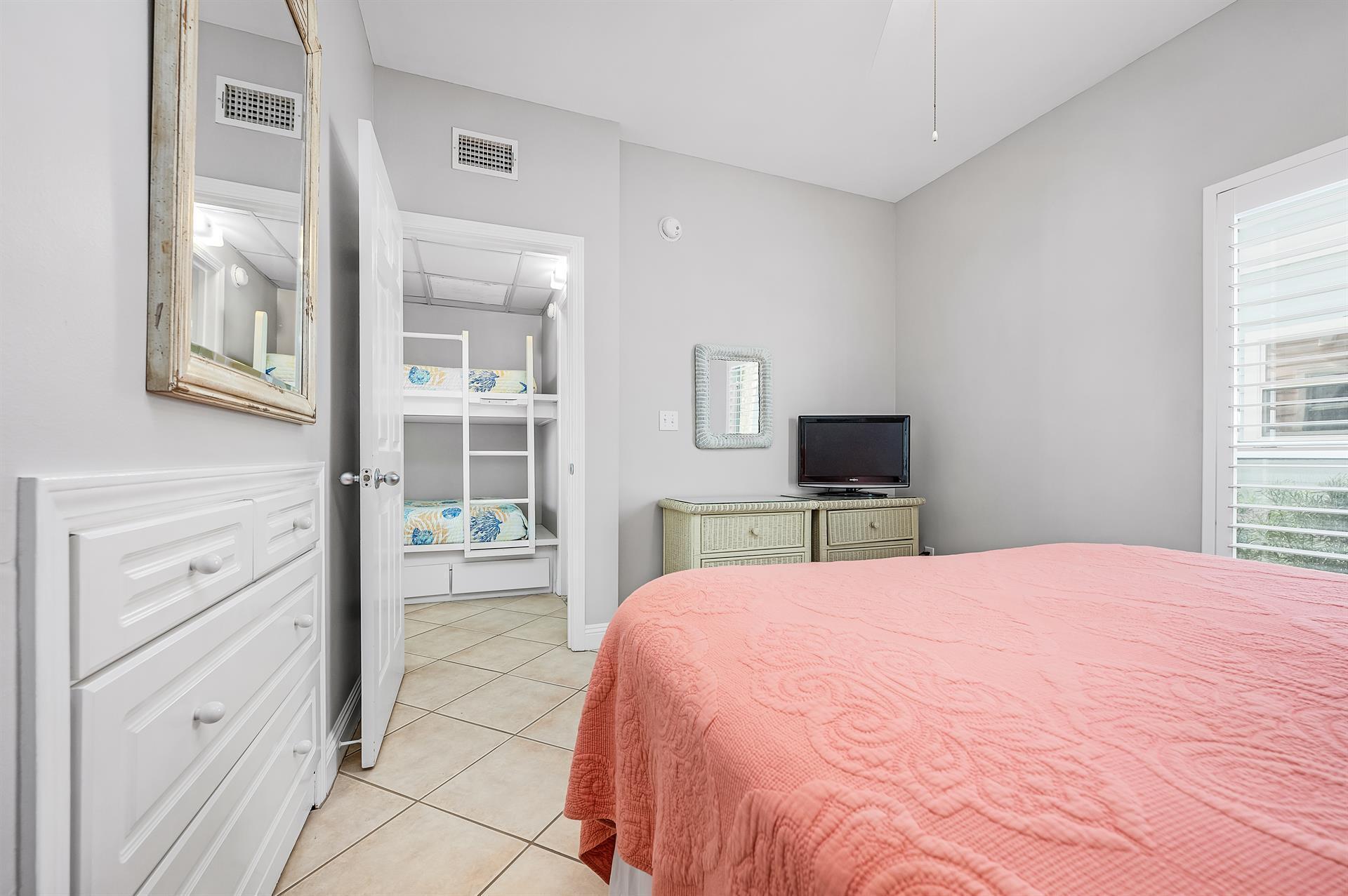 69 Crystal Beach Drive, Unit 8 Destin, FL 32541 - Photo 34 of 51 a large bedroom with a bed and a flat screen tv