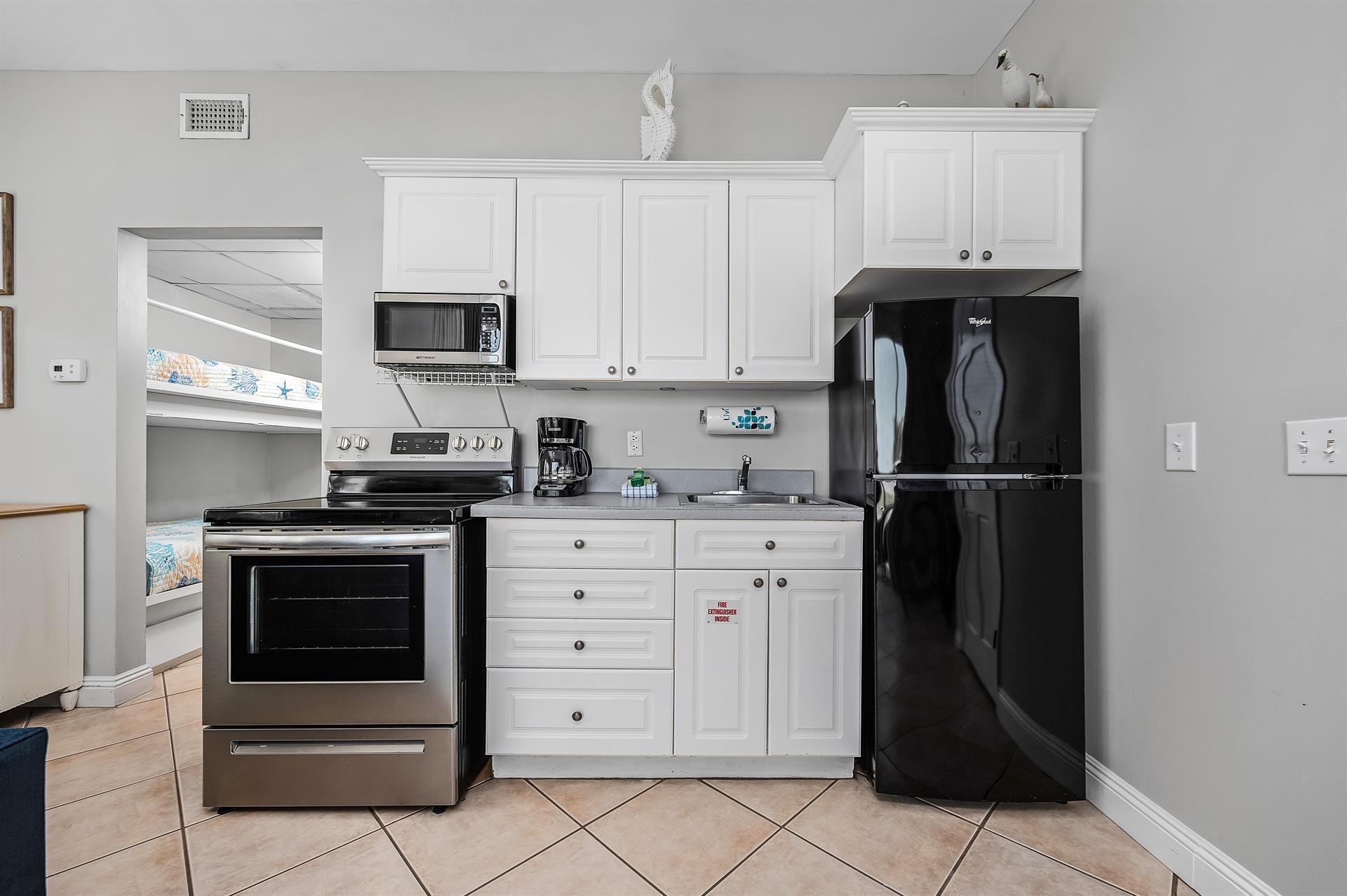 69 Crystal Beach Drive, Unit 8 Destin, FL 32541 - Photo 38 of 51 a kitchen with stainless steel appliances granite countertop a refrigerator stove and white cabinets