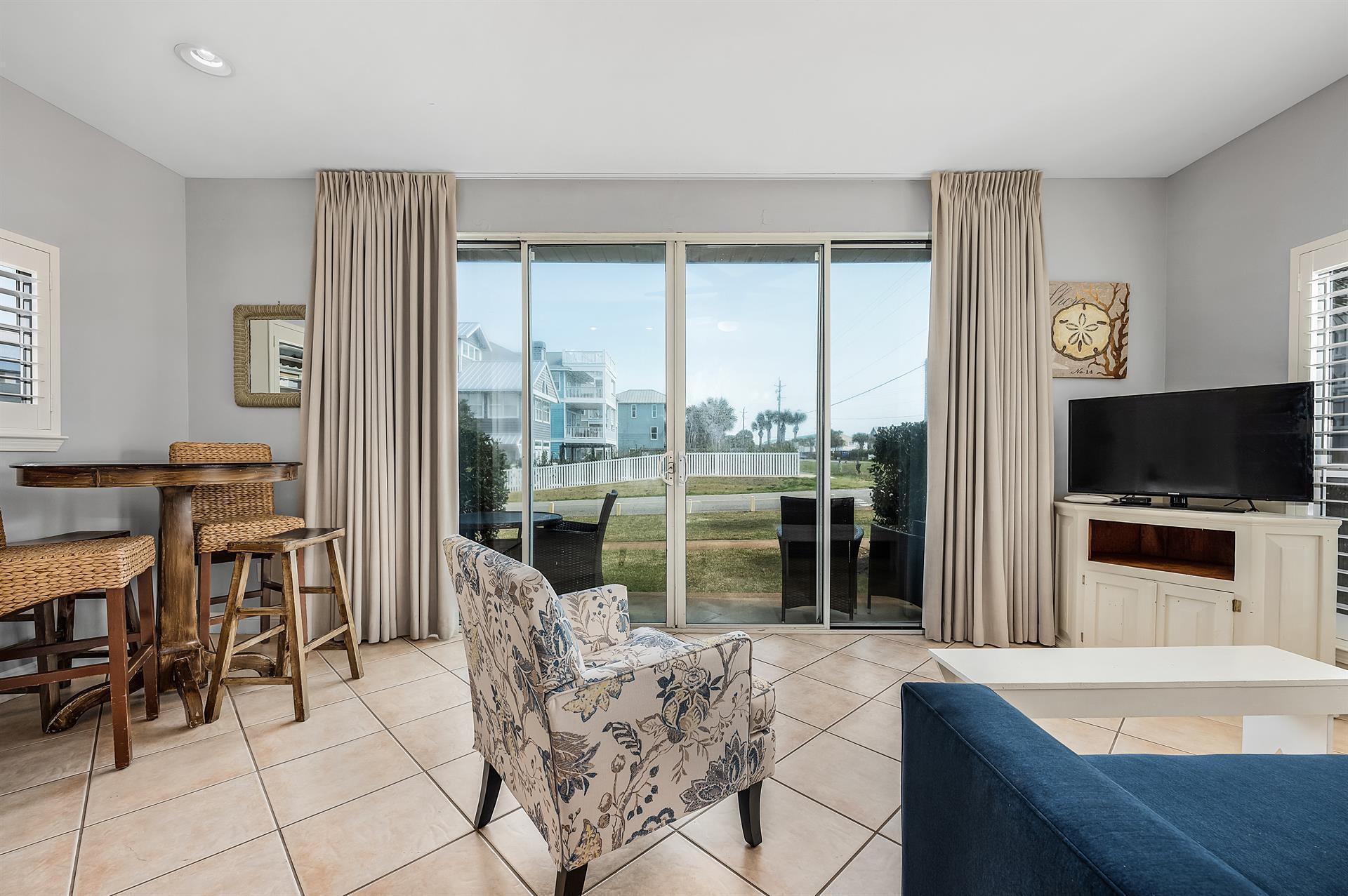 69 Crystal Beach Drive, Unit 8 Destin, FL 32541 - Photo 41 of 51 a living room with furniture a flat screen tv and a large window