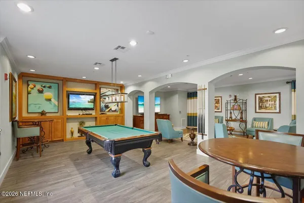 a living room with furniture a table and kitchen view