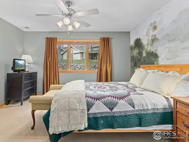 a bedroom with a bed and a flat tv screen on dresser