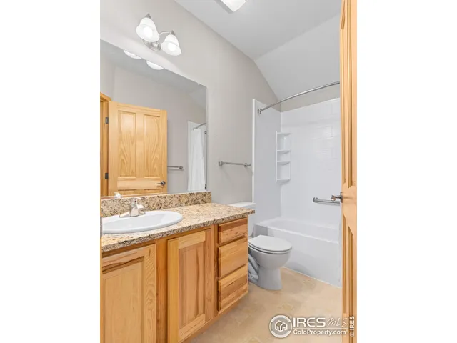 a bathroom with a granite countertop sink a toilet and a mirror