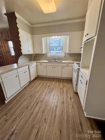 a kitchen with cabinets a sink and wooden floor