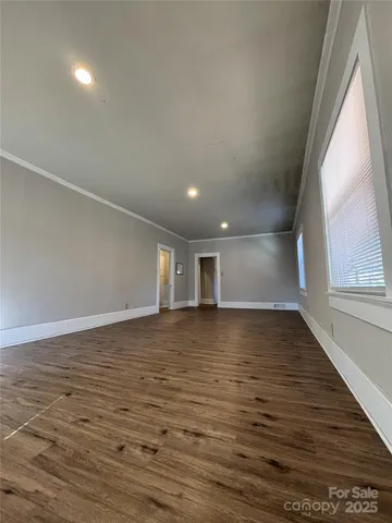 a view of a room with wooden floor and window