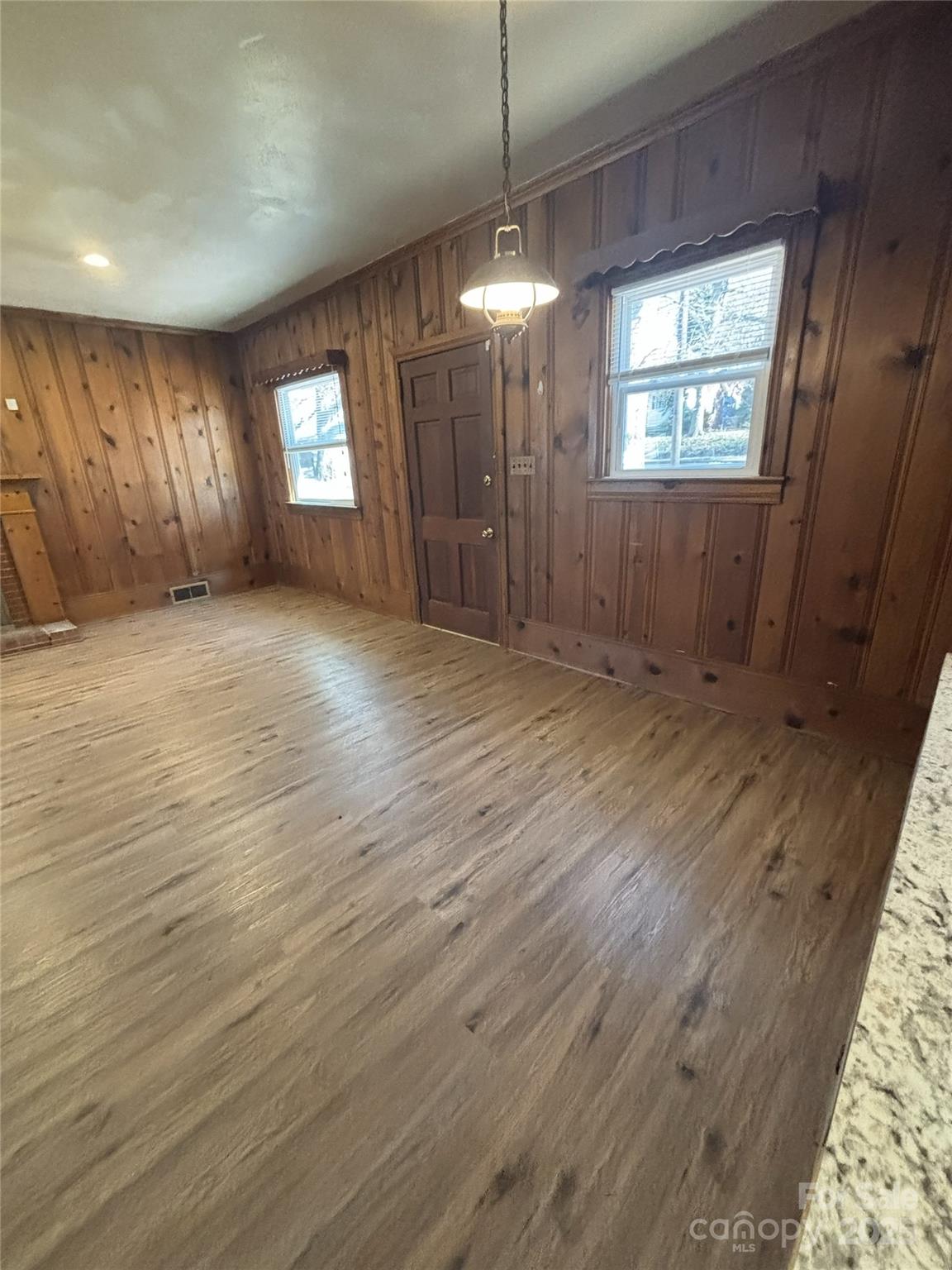 455 Spring Street Albemarle, NC 28001 - Photo 8 of 32 an empty room with wooden floor and windows