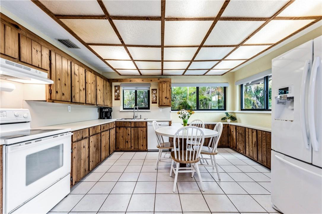 11301 Southwest 16th Street Davie, FL 33325 - Photo 14 of 54 a kitchen with a dining table chairs and white appliances