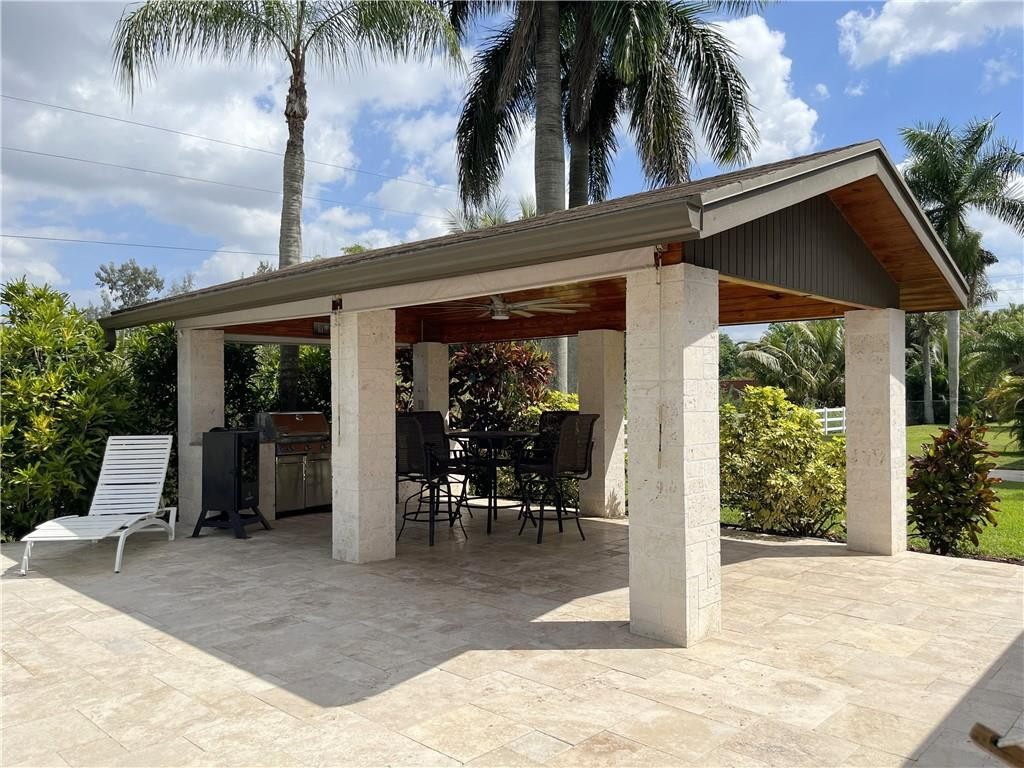 11301 Southwest 16th Street Davie, FL 33325 - Photo 6 of 54 a view of a patio with table and chairs potted plants and palm tree
