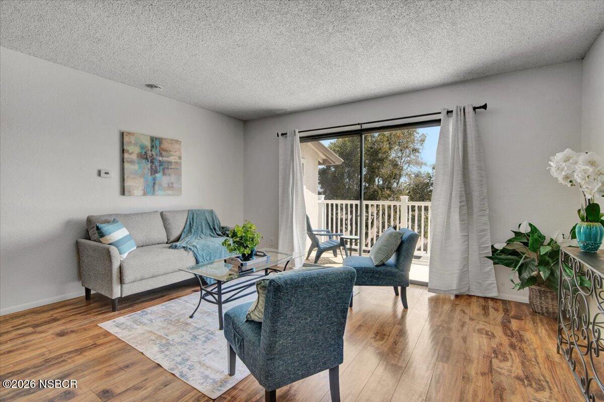 3400 Santa Maria Way, Unit 207B Santa Maria, CA 93455 - Photo 10 of 50 a living room with furniture and a large window with wooden floor