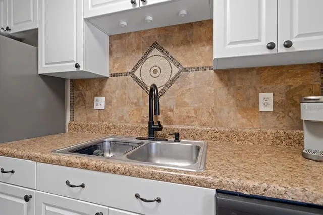 a kitchen with granite countertop a sink and cabinets