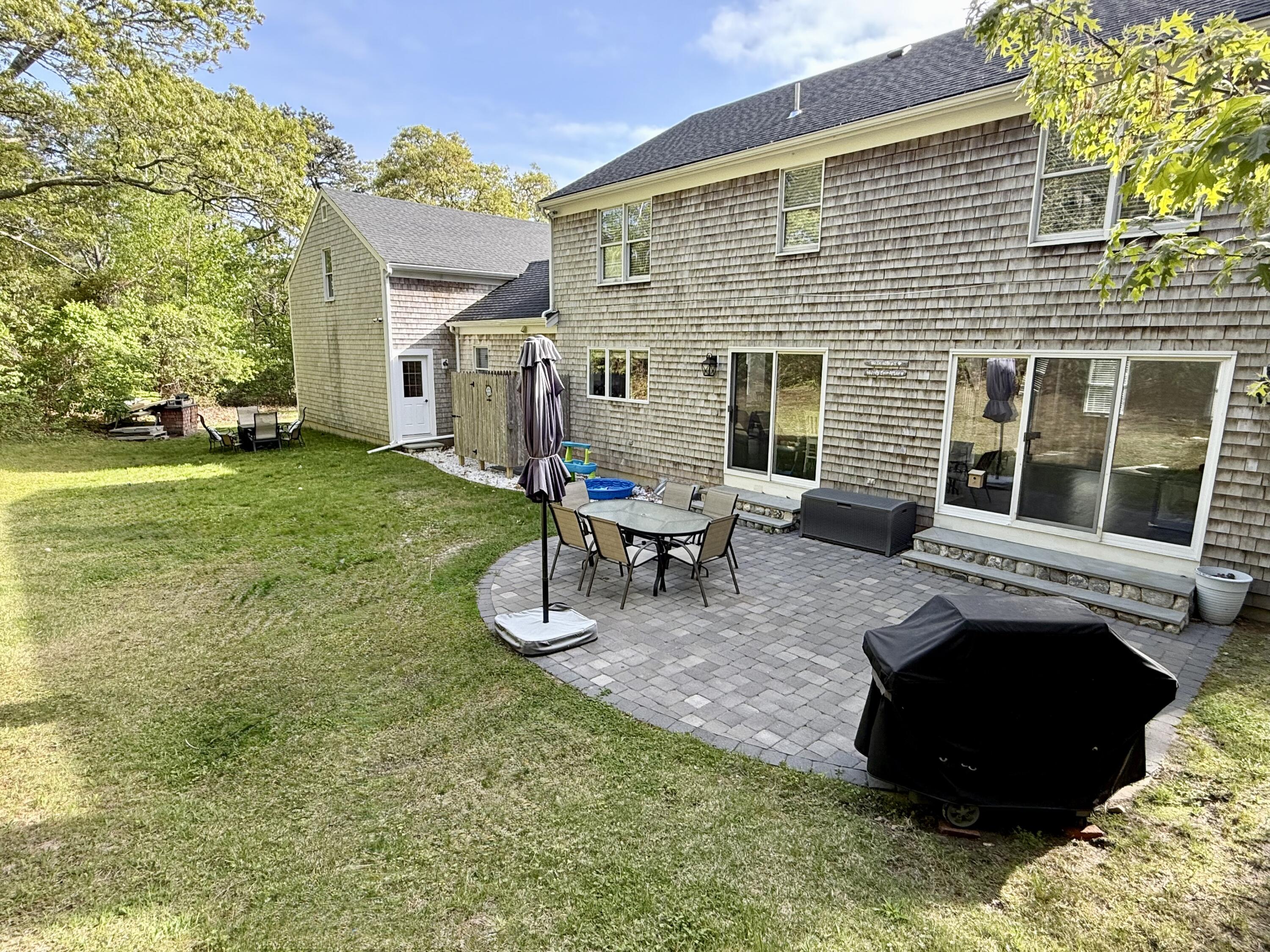 117 A P Newcomb Road Brewster, MA 02631 - Photo 62 of 69 a backyard of a house with table and chairs