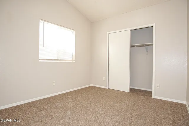 an empty room with windows and closet