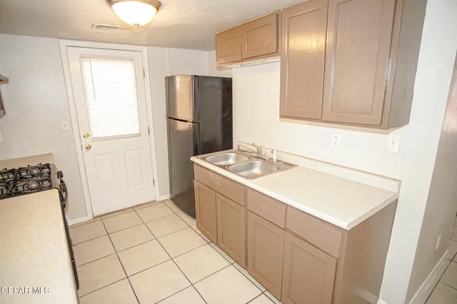 a kitchen with a refrigerator sink and cabinets