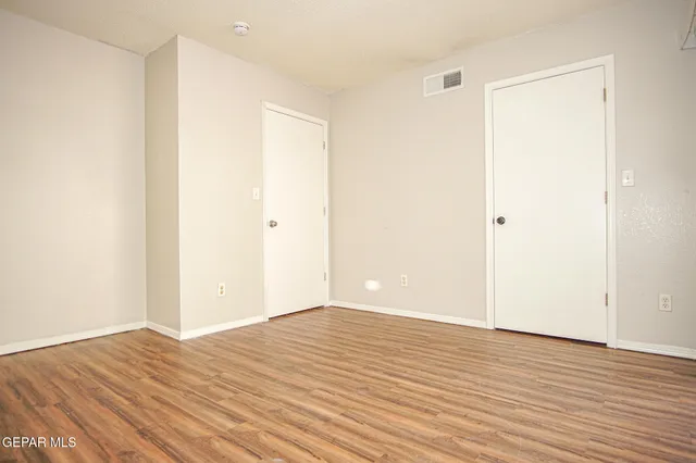 a view of an empty room with wooden floor
