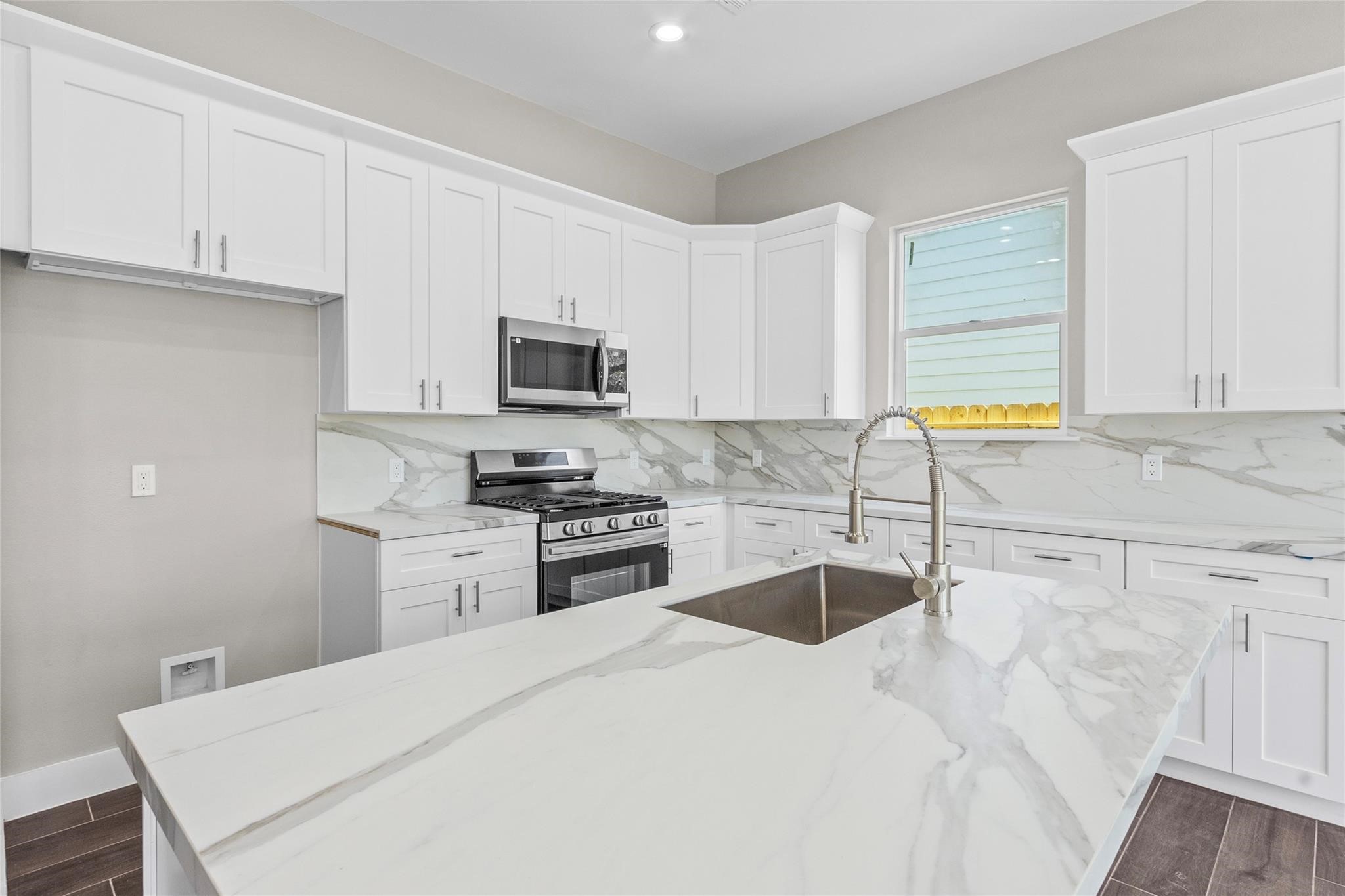 5506 Pershing Street Houston, TX 77033 - Photo 7 of 29 a kitchen with stainless steel appliances granite countertop a sink a stove top oven a granite counter tops and white cabinets