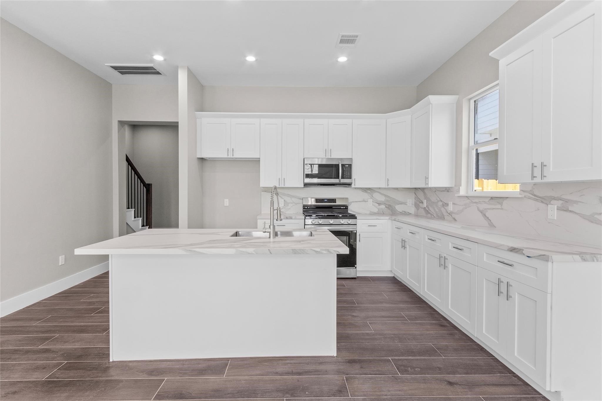 5506 Pershing Street Houston, TX 77033 - Photo 9 of 29 a kitchen with kitchen island a white counter top space cabinets and stainless steel appliances