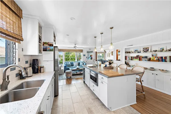 a kitchen that has a lot of cabinets a sink and wooden floor