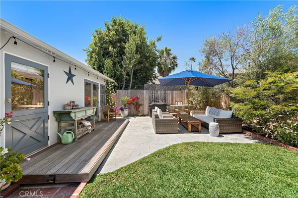 a view of a patio with furniture and a table and chairs under an umbrella