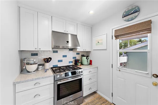 a kitchen with cabinets appliances a sink and a window