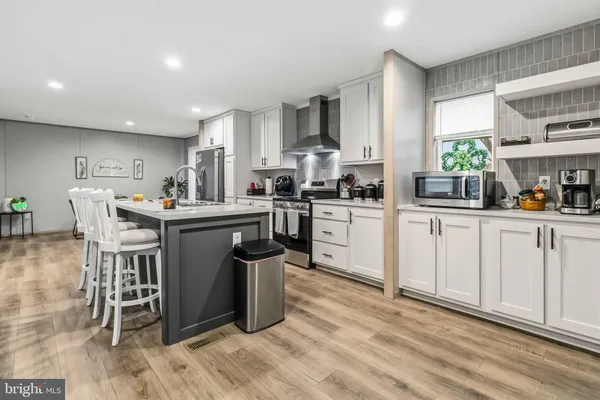 a kitchen with white cabinets sink and appliances