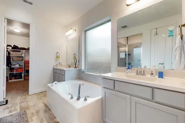 a bathroom with a tub sink and mirror