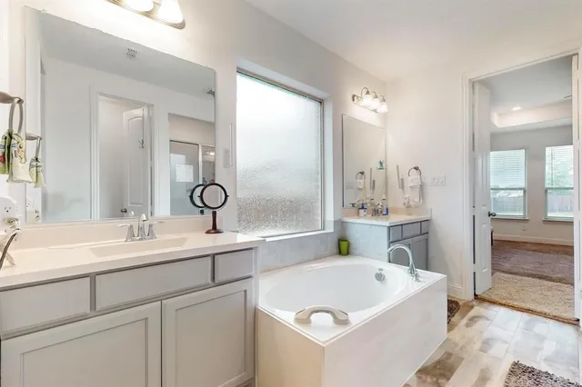a bathroom with a tub a sink and a mirror