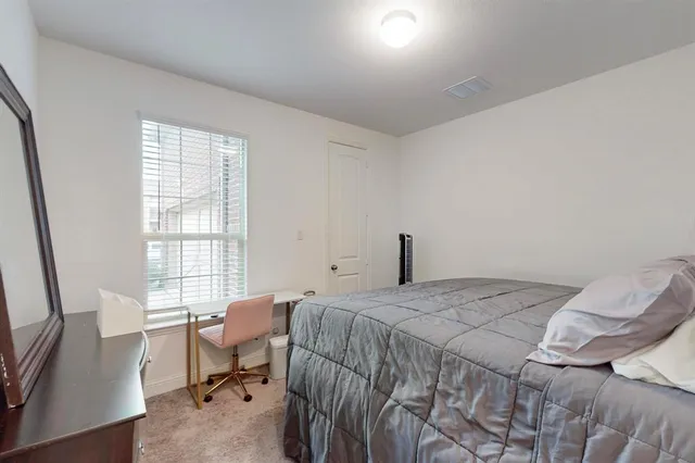 a bedroom with a bed chair and a window