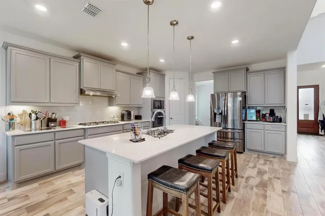 a kitchen with a sink stainless steel appliances and cabinets