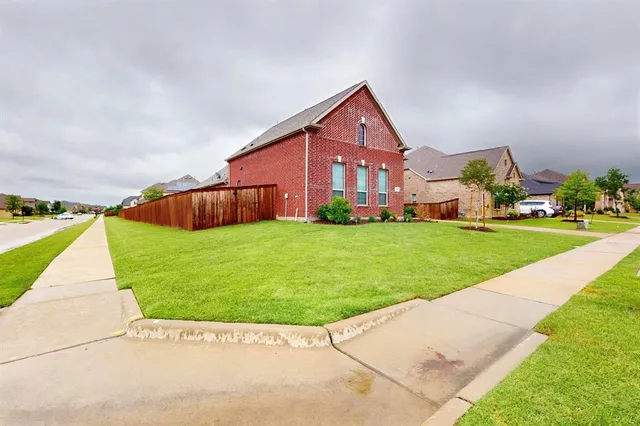 a view of a house with a yard and potted plants