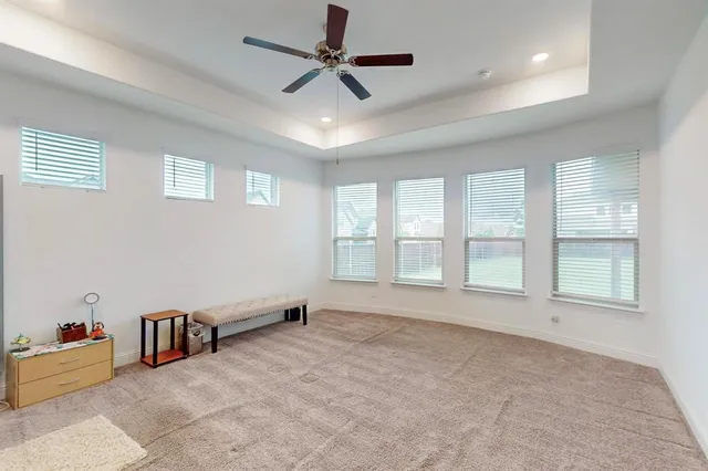 a view of an empty room with a window and a kitchen