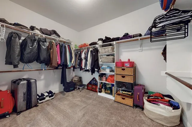 a view of walk in closet with clothes and shoes