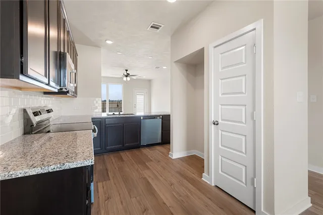 a kitchen with stainless steel appliances granite countertop a sink stove and refrigerator
