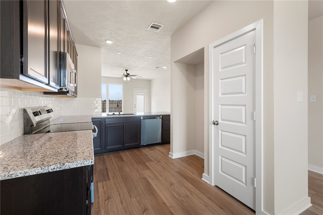 2427 Rooke Road Bryan, TX 77807 - Photo 11 of 38 a kitchen with stainless steel appliances granite countertop a sink stove and refrigerator