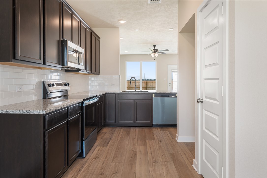 2427 Rooke Road Bryan, TX 77807 - Photo 12 of 38 a kitchen with stainless steel appliances granite countertop a sink a stove and refrigerator