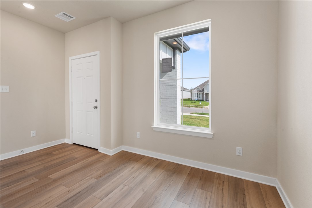 2427 Rooke Road Bryan, TX 77807 - Photo 13 of 38 an empty room with wooden floor and windows
